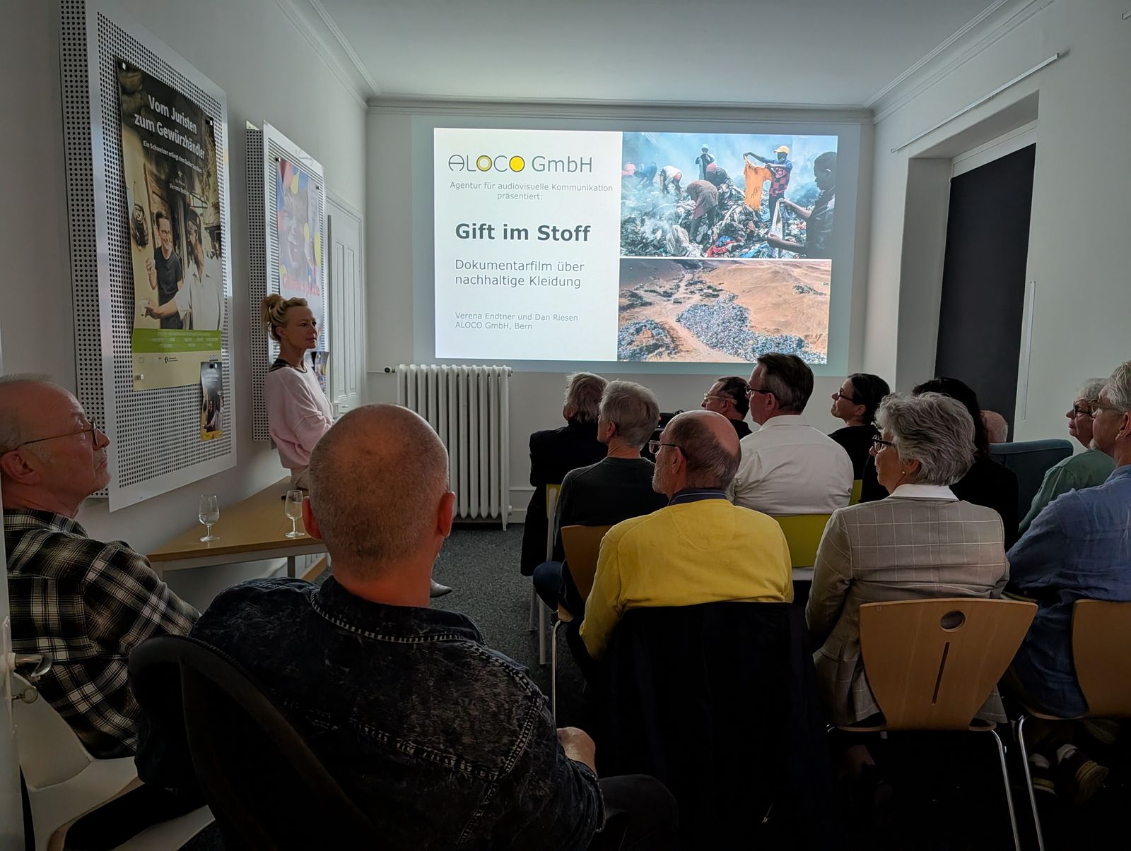 Referentin neben der Präsentation «Gift im Stoff» vor dem Publikum des Usitawi-Abends bei ALOCO.