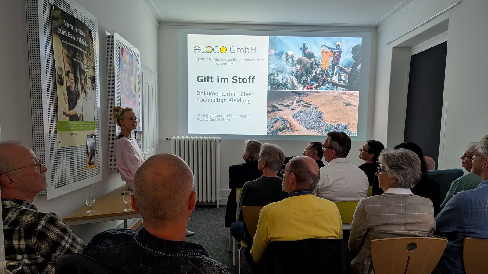 Referentin neben der Präsentation «Gift im Stoff» vor dem Publikum des Usitawi-Abends bei ALOCO.